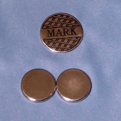 Personalized flat golf marker beside two coin sized magnets